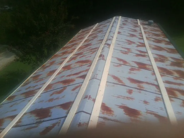 Rusted metal roof panels with new wood purlins before replacement — Storm Damage Roof Repair in Mooreland by Roofing Brothers
