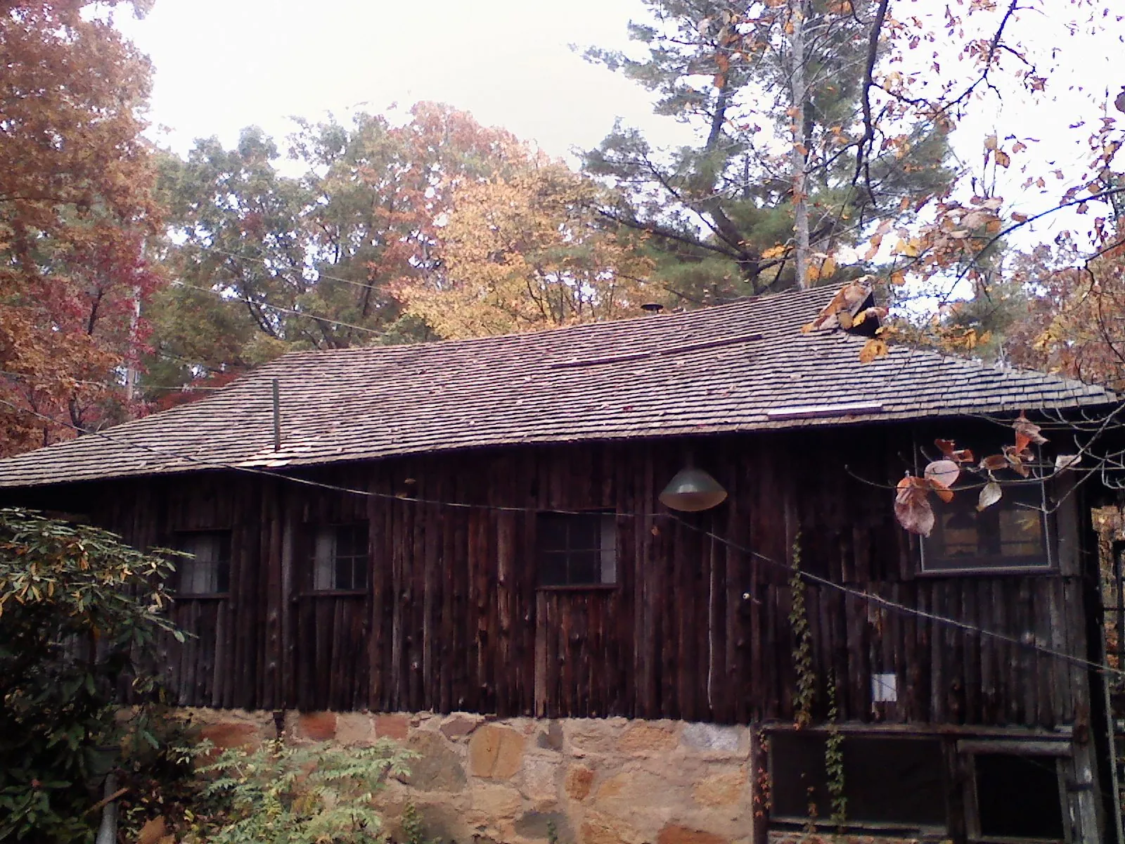 Weathered wood shake roof on a rustic board sided cabin in Mooreland